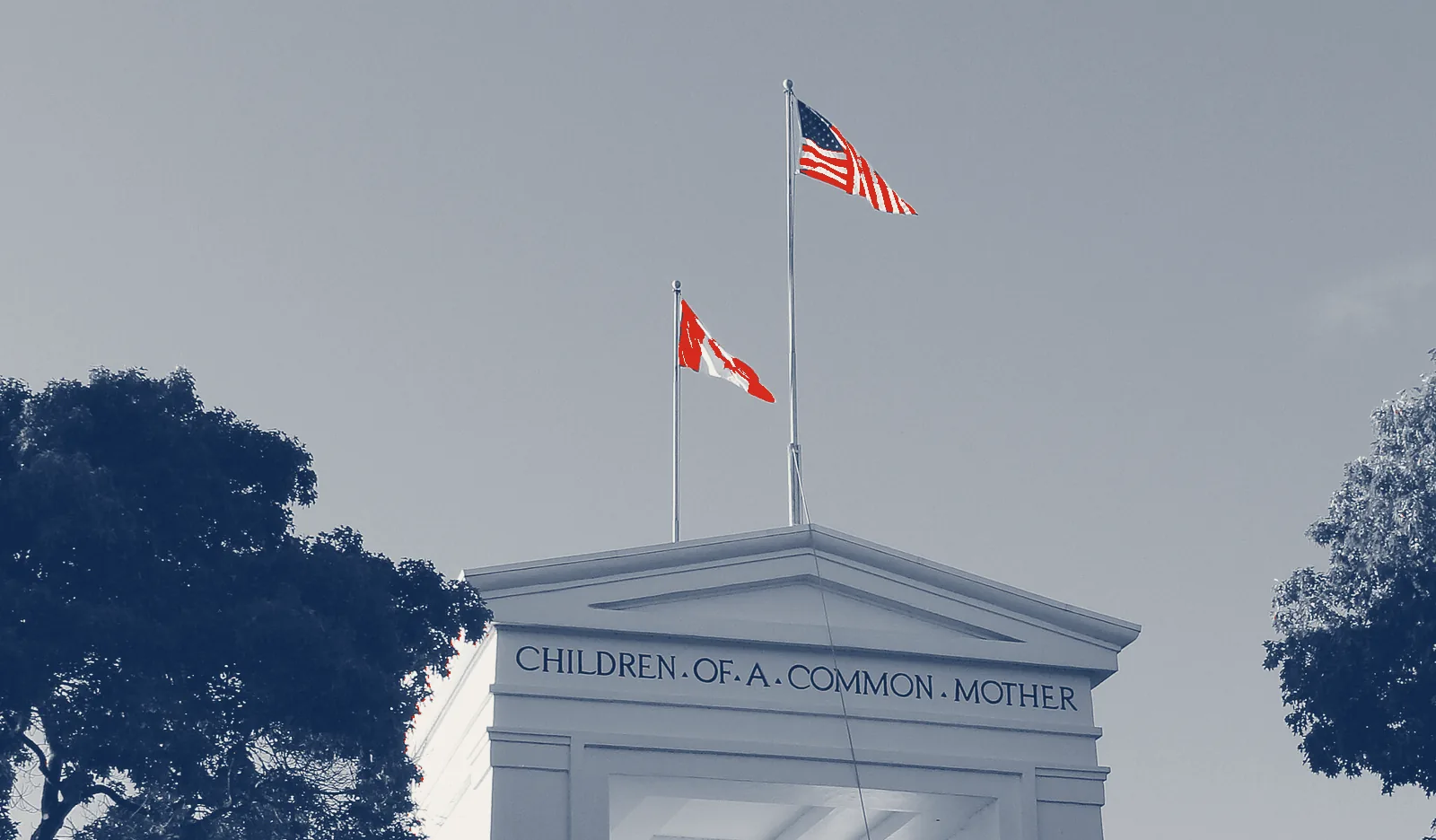 The Peace Arch on the Canada–US border at Blaine, Washington, carved with the words CHILDREN OF A COMMON MOTHER, the American and Canadian flags flying above it.